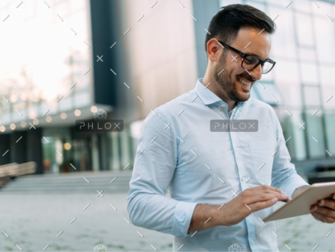 demo-attachment-2721-portrait-of-businessman-in-glasses-holding-tablet-AWVHCJU